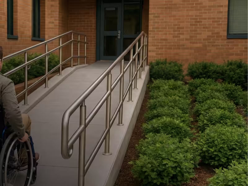 Wheelchair access ramp with handrails beside a garden bed